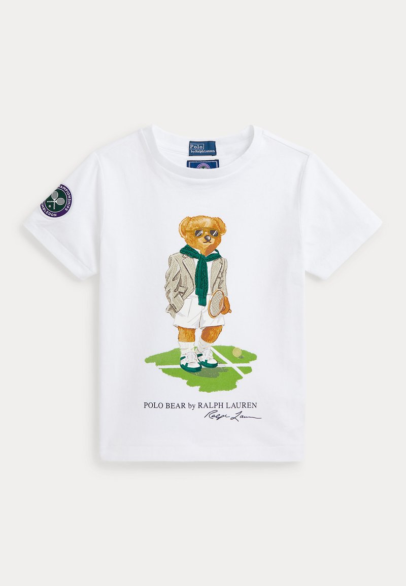 Λευκό βαμβακερό μπλουζάκι με σχέδιο αρκούδας σε γυαλιά ηλίου, φορώντας σακάκι και πράσινο κασκόλ, κρατώντας ρακέτα τένις με λεπτομέρειες γρασιδιού και λογότυπο.