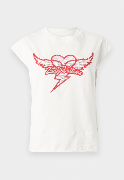 Λευκό βαμβακερό T-shirt με κοντά μανίκια καπέλου, που φέρει κόκκινο γραφιστικό σχέδιο μιας καρδιάς με φτερά και έναν κεραυνό, περιτριγυρισμένο από διακοσμητικά καρφιά.