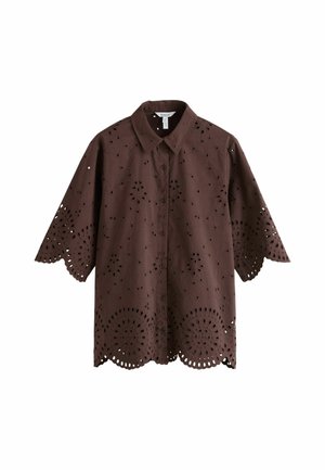 Brun skjorte med knapper med bølgede kanter og blomsterudskæringer med hulmønster på ærmer og kant.