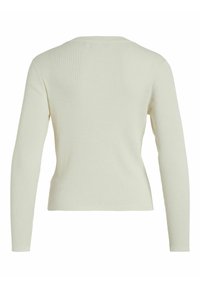 Top de manga larga acanalado en crema claro; diseño ajustado con escote redondo y textura suave. Espalda sin costuras para un acabado limpio.