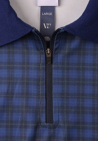 Pamučna polo majica tamnoplave karirane boje s patentnim zatvaračem, s jednobojnim tamnoplavim ovratnikom. Ima mekanu teksturu i kroj koji prianja uz tijelo. Veličina: velika.