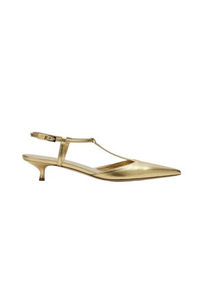 Chaussure slingback dorée à bout pointu, talon kitten bas et fine bride en T avec fermeture à boucle sur fond blanc.