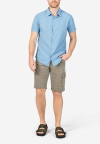 Light blue striped short-sleeve shirt, khaki cargo shorts with side pockets, and brown sandals. The outfit has a casual, summer appeal.