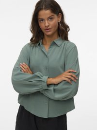 Light green button-up shirt with a collar, long puff sleeves, and a curved hem. Made from a smooth, lightweight fabric.