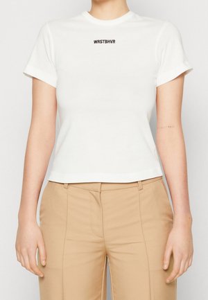 T-shirt blanc à manches courtes avec une coupe ajustée, arborant le texte noir "WRSTBHV" sur la poitrine et une texture en coton lisse.