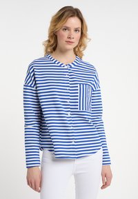Gestreepte overhem shirt met blauwe en witte horizontale strepen, een ronde halslijn en een voorzak met verticale strepen, gemaakt van zachte stof.