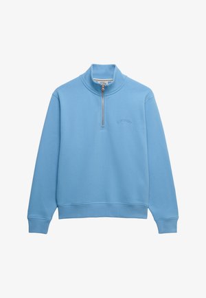Sweat-shirt bleu clair à fermeture éclair jusqu'au quart, avec poignets et ourlet côtelés, col haut, et logo de marque brodé discret sur la poitrine.