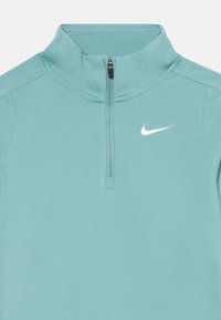 Helle teal Zip-Jacke aus glattem, elastischem Stoff; verfügt über einen hohen Kragen und ein kleines weißes Nike-Logo auf der linken Brust.