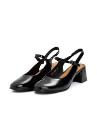Tacones slingback de charol negro con punta redonda, correa ajustable y tacón cuadrado. Textura suave y acentos mínimos.