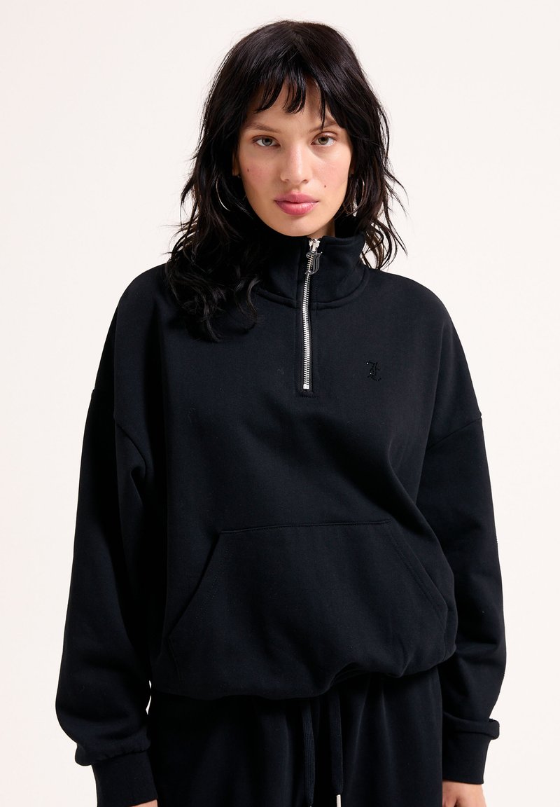 Sweatshirt noir avec col haut, demi-zip et poche kangourou. Tissu doux, coupe décontractée et détail de logo subtil sur la poitrine.