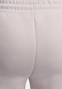 Leggings rosa chiaro con tessuto elasticizzato e superficie testurizzata. La vita è elastica e si arriccia nella parte superiore.