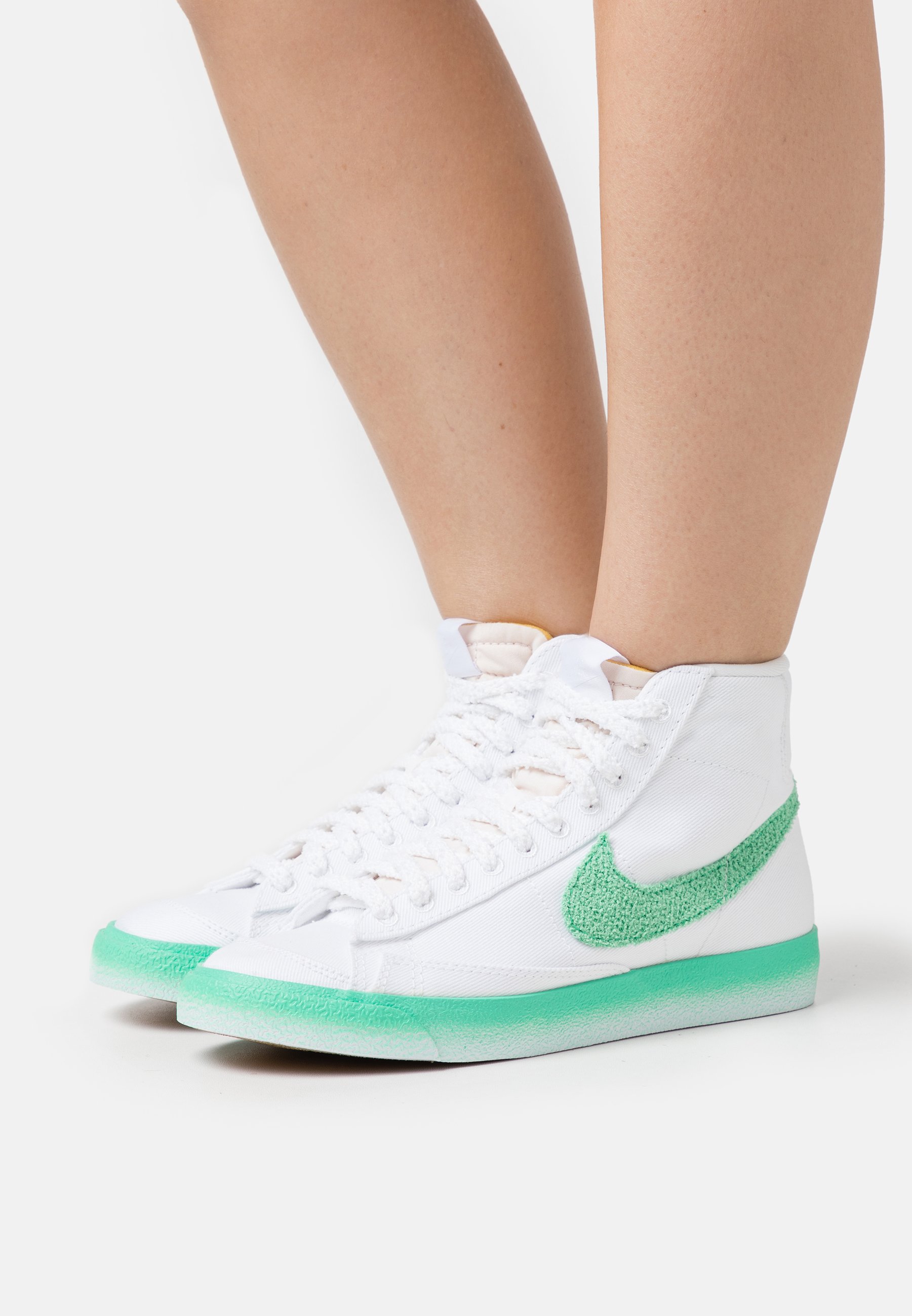 white and green nike trainers