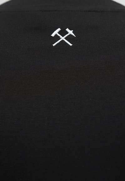 Μαύρο ύφασμα με μικρό λευκό κεντημένο σχέδιο διασταυρωμένου σφυριού και πικάγου τοποθετημένο στο κέντρο κοντά στην κορυφή.