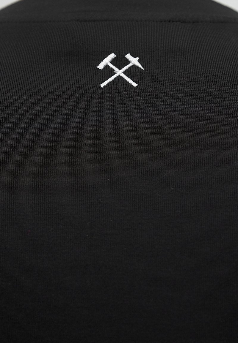 Black fabric with a small white embroidered design of a crossed hammer and pickaxe centered near the top.