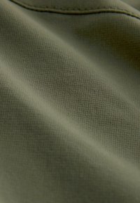 Olivgrüner, strukturiert gewebter Stoff mit leichter Glanzwirkung, glatter Oberfläche und subtilen Webmustern sowie kontrastierenden Nähten am Rand.