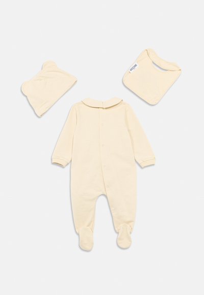 Βρεφικός φορμάκος εκρού χρώματος με μακριά μανίκια, κλειστά πατουσάκια, στρογγυλό γιακά και σετ που περιλαμβάνει καπέλο με αυτιά αρκούδας και σαλιάρα, φτιαγμένο από μαλακό ύφασμα.