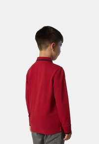 Polo shirt rosso a maniche lunghe con colletto e polsini in contrasto blu navy, realizzato in un tessuto testurizzato e dotato di spacchi laterali all'orlo.