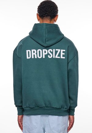 Türkisfarbener Kapuzenpullover mit lockerer Passform, der einen weißen "DROPSIZE"-Druck auf dem Rücken hat. Weiche Textur, gerippte Bündchen und Saum.