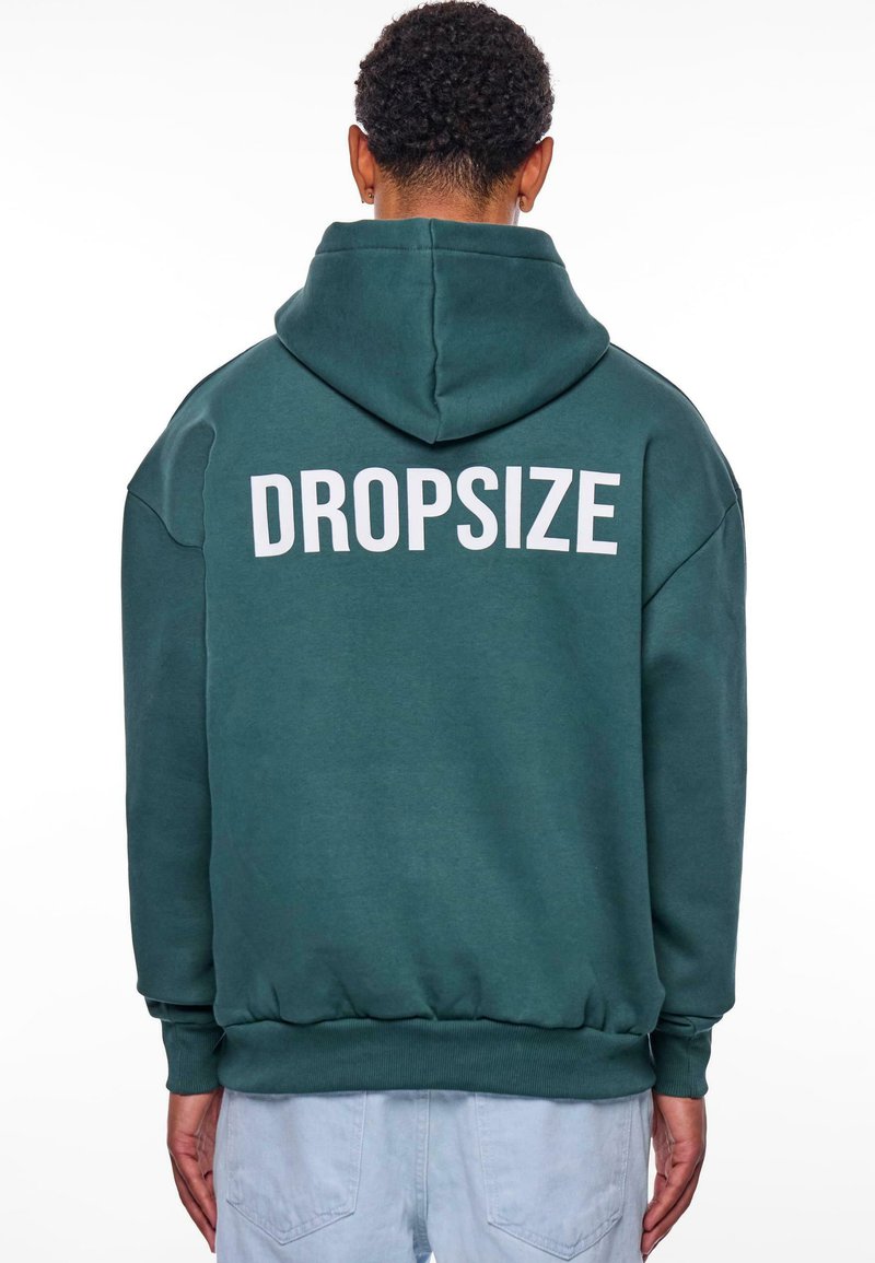 Teal värvi kapuutsiga sviiter, millel on lahtine lõige ja mille seljal on valge "DROPSIZE" trükk. Pehme tekstuur, soonikkoes varrukad ja äär.