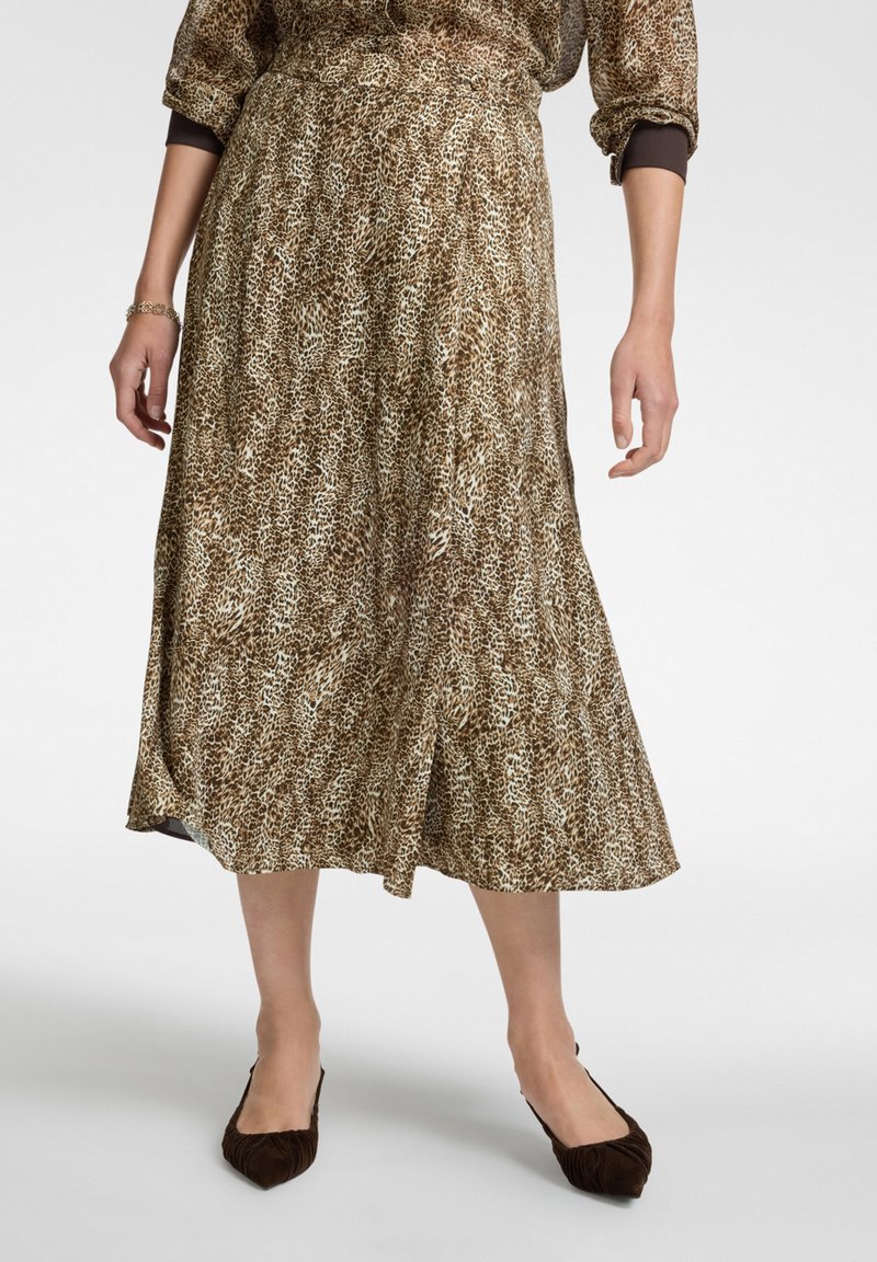 Gonna midi marrone e crema con stampa leopardata, realizzata in un tessuto leggero e fluido. Vita elastica e dettaglio con spacco laterale.