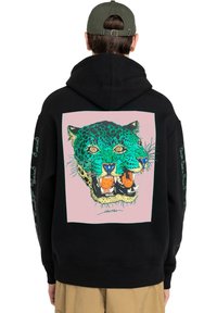 Sudadera negra con un gran gráfico de leopardo colorido sobre un fondo rosa. Presenta un corte relajado y capucha con cordón; tejido texturizado.