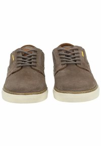 Zapatillas de ante marrón con una superficie texturizada y suela de goma, que cuentan con cierre de cordones y un pequeño acento amarillo.
