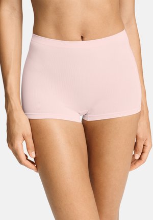 Kvinde iført lyserøde seamless high-waist boyshort trusser, vist fra mave til øvre lår mod en hvid baggrund.