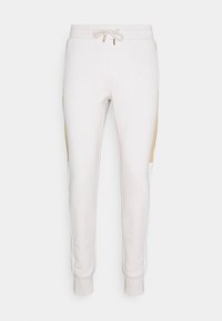 Elfenbensfarvede sweatpants med snøre i taljen, med beige og hvide sidepaneler. Lavet af blødt, strækbart stof med ribbede manchetter.