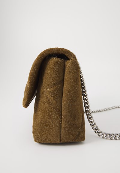 Geantă de mână din nubuc maro, cu un design pliat, având o curea din lanț argintiu și detalii cusute pe margini. Formă rectangulară compactă.