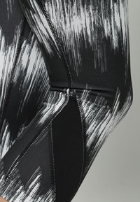 Czarno-białe legginsy w wzory z miękką strukturą, z płaskimi szwami i gładkim, elastycznym materiałem dla wygody.