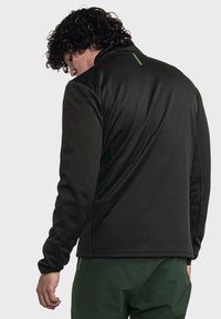 Schwarze Fleecejacke mit hohem Kragen und strukturiertem Finish, mit einem dezenten grünen Logo auf dem Rücken und gerippten Bündchen.