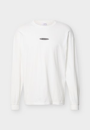 Weißes Langarmshirt mit Rundhalsausschnitt, kleinem schwarzem ovalem Logo und weißem Text mittig auf der Brust.