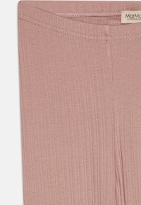 Púder rózsaszín bordázott leggings puha anyagból, rugalmas derékkal, és jellegzetes függőleges bordázási mintával a textúra érdekében.