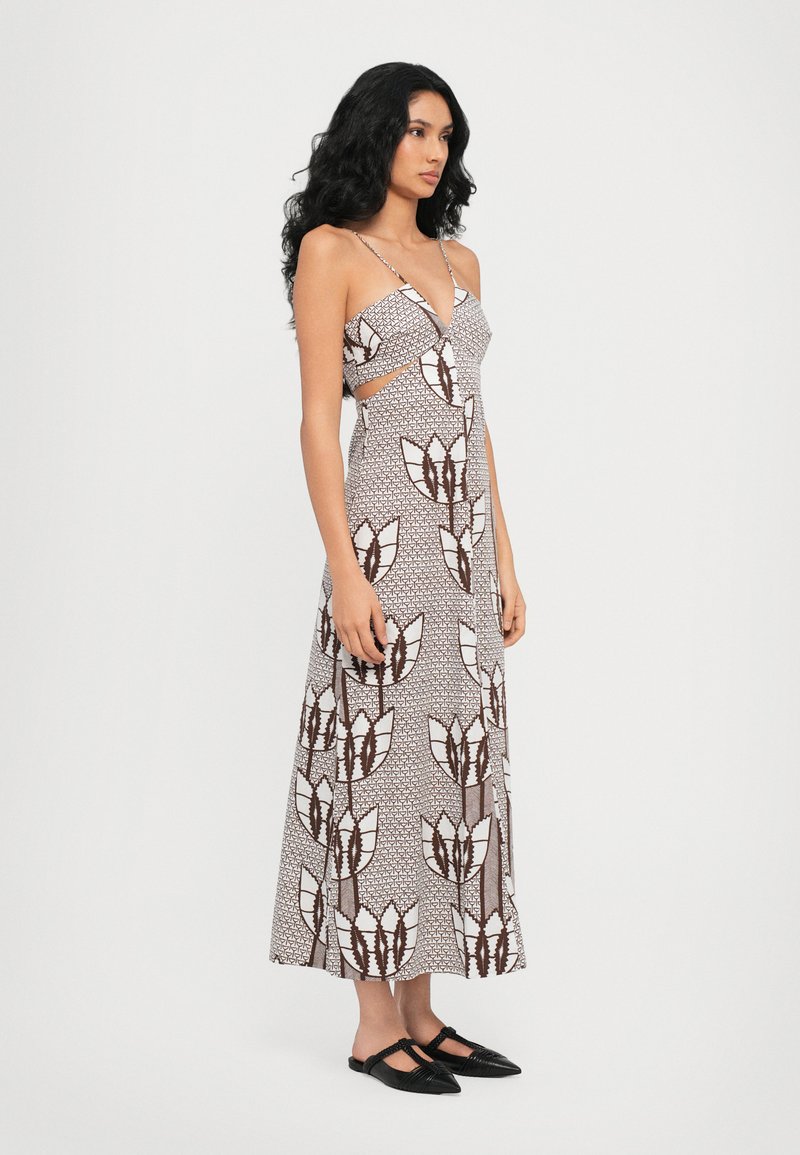Abito lungo e stampato con scollatura a V profonda, lati con tagli e spalline sottili. Presenta un motivo floreale in marrone e bianco su tessuto leggero.