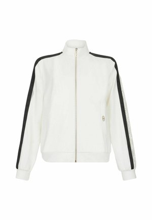 Veste blanche zippée avec des rayures noires sur les côtés ; dotée d'un col montant, de deux poches avant et de poignets côtelés. Tissu doux avec une texture lisse.