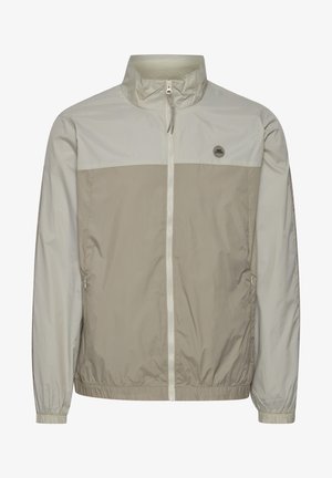 Chaqueta ligera y resistente al agua en beige y gris claro. Cuenta con un cuello alto, cierre frontal completo, puños elásticos y bolsillos laterales.