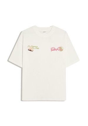 T-shirt blanc manches courtes avec texte vert et graphique cigare sur la poitrine gauche et texte rose « Puerto Rico » avec logo palmier sur la poitrine droite.