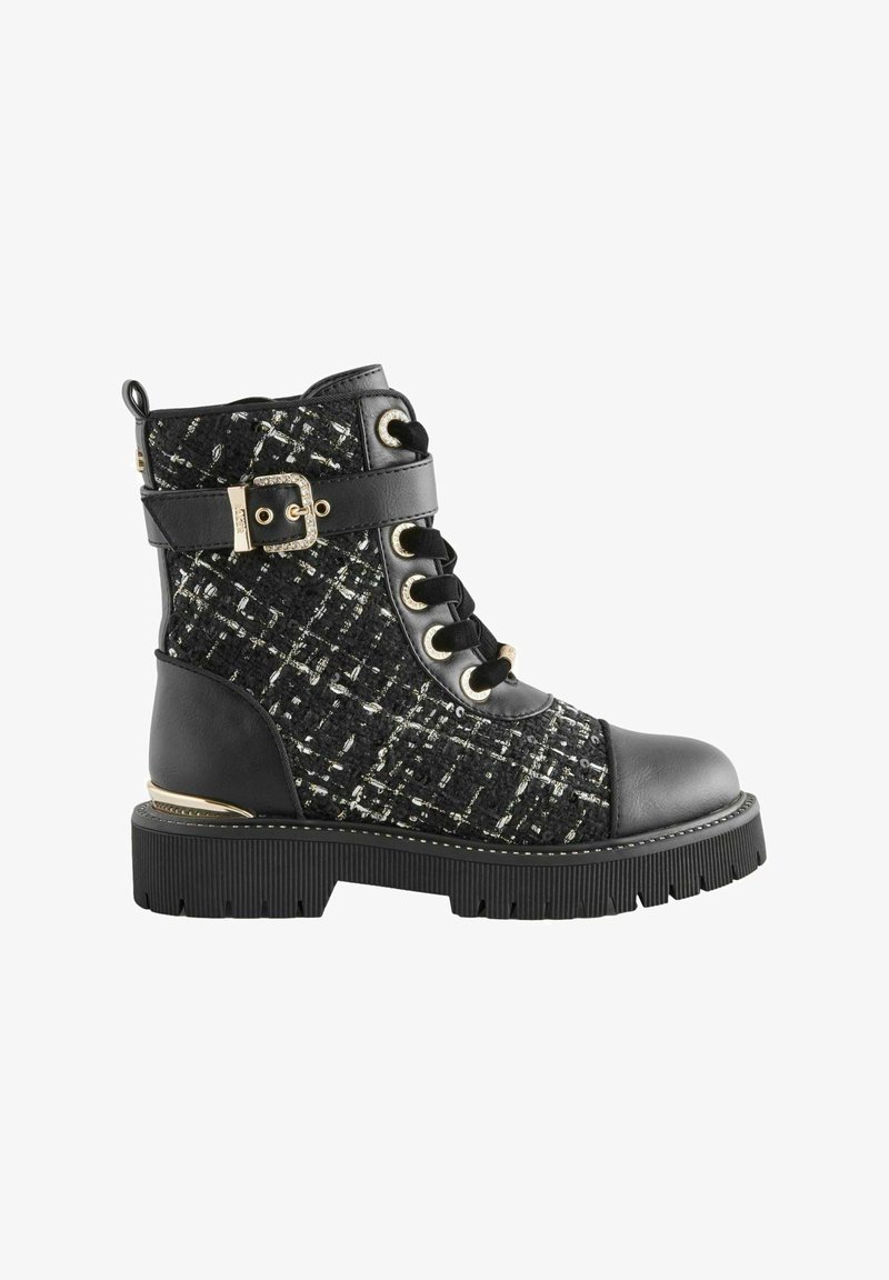 Juodas ir tweed ankle botas su raištelių priekyje, sagties akcentu, guminiu padu ir metaliniais akcentais. Yra tekstūruota medžiaga ir lygi oda.