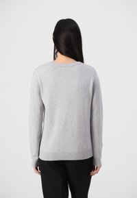 Grauer gestrickter Pullover mit langen Ärmeln, Rundhalsausschnitt und geripptem Saum. Der Stoff wirkt weich mit einer glatten Textur. Keine auffälligen Muster.