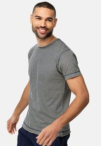 Marineblå og kremfarget T-skjorte med kort erm som har et geometrisk mønster, rund hals og teksturert stoff. Tett passform med synlige trim-detaljer.
