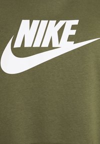 Olivově zelená mikina s výrazným bílým logem "NIKE" a ikonickým swoosh, vyrobená z bavlněné směsi s hladkou texturou.