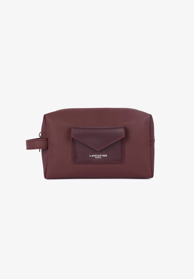 Necessaire bordeaux realizzato in materiale sintetico testurizzato, con una tasca frontale e logo impresso sulla patta. Chiusura con zip sulla parte superiore.