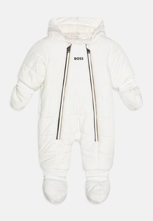 Tuta da neve imbottita bianca con cappuccio, caratterizzata da cerniere nere e marroni e un logo "BOSS" sul petto. Include copri-mani e copri-piedi.