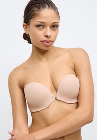 Σουτιέν χωρίς τιράντες σε γυμνό χρώμα από απαλό ύφασμα με σχεδιασμό καλύμματος που είναι  καλουπωμένο και χωρίς ραφές, με κούμπωμα στο μπροστινό μέρος.