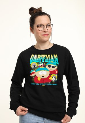 Donna con occhiali che indossa una felpa nera con il personaggio di South Park Cartman e il testo "Vaffanculo ragazzi, torno a casa!"