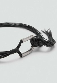 Sangle noire multifonction en textile tressé fin, dotée d'une boucle métallique et d'une extrémité nouée, avec des bords effilochés.