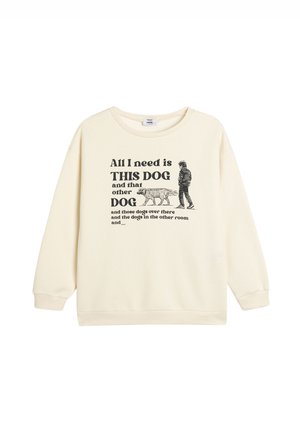 Sudadera color crema de corte holgado, con una impresión gráfica de una persona y perros. Mangas largas y escote redondo.