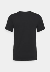 Camiseta de algodón negra con mangas cortas, cuello redondo y textura suave; no hay gráficos ni adornos visibles.