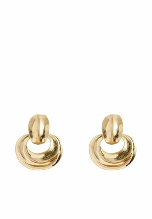 Gold-toned earrings feature a circular design with a flat top and a hollow, wavy, rounded hanging section. Reflective metal finish.