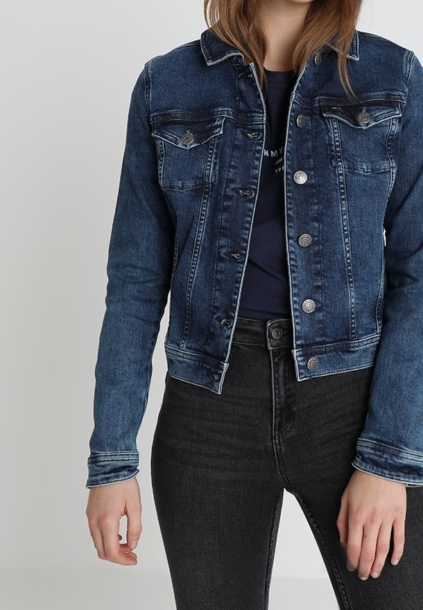Denimjacka i mörkblått med knäppning fram, två bröstfickor och en klassisk krage. Har subtil blekning och en cropped design.